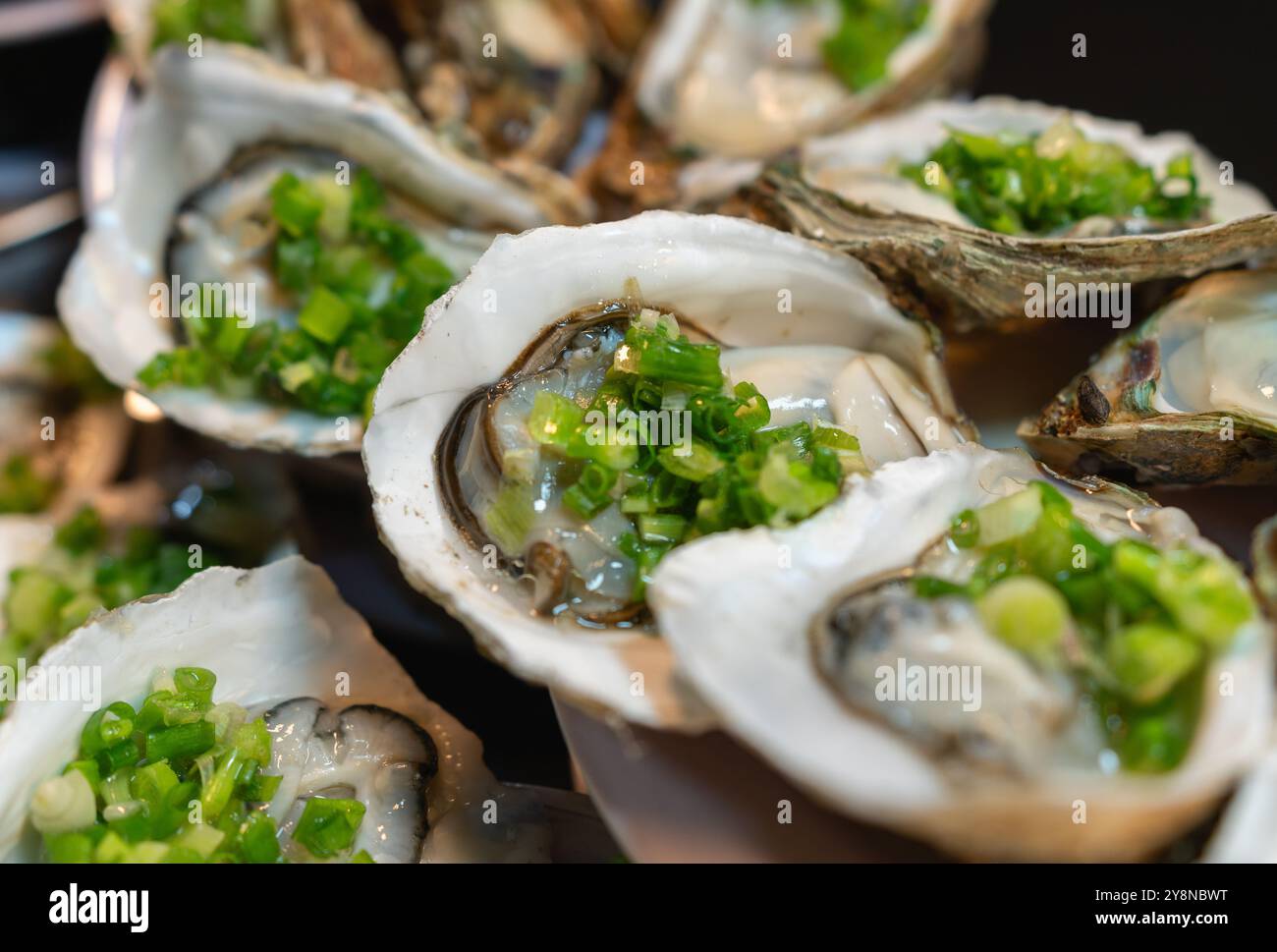Ostriche fresche condite con cipolle verdi e succo di limone Foto Stock