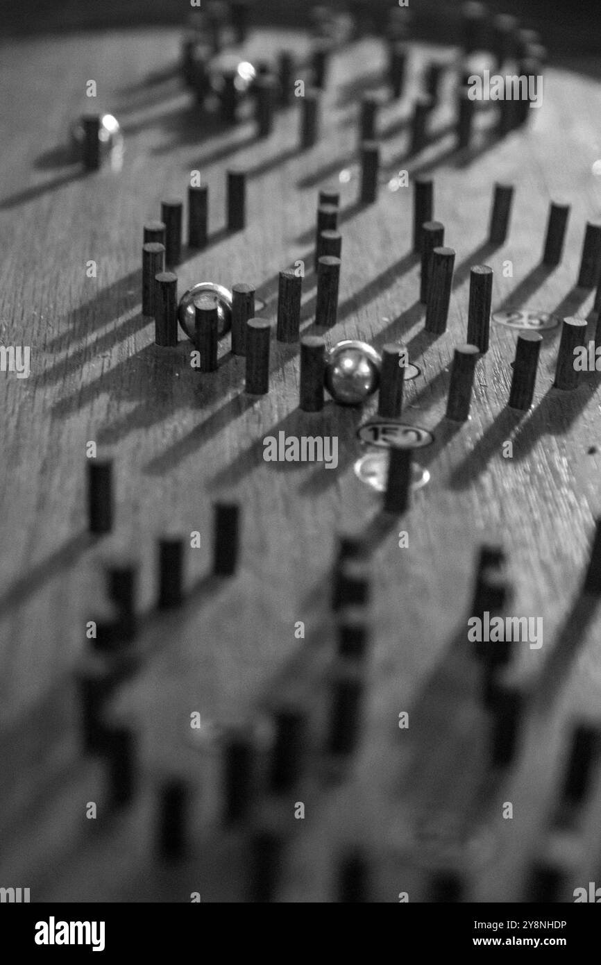Riprendendo l'essenza della strategia e della nostalgia, questo primo piano di un tabellone Bagatelle ti invita a lanciare le palle e ad accettare la sfida giocosa. Foto Stock