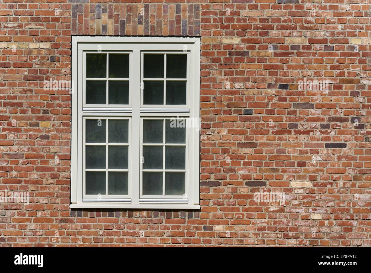 Finestra con cornice bianca su uno storico edificio in mattoni in Germania Foto Stock