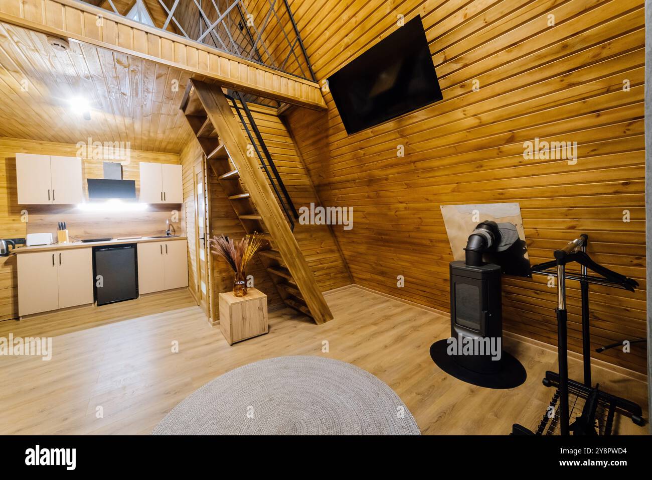 Cabina interna moderna in legno con cucina e zona loft, perfetta per rilassarsi e rifugi accoglienti Foto Stock
