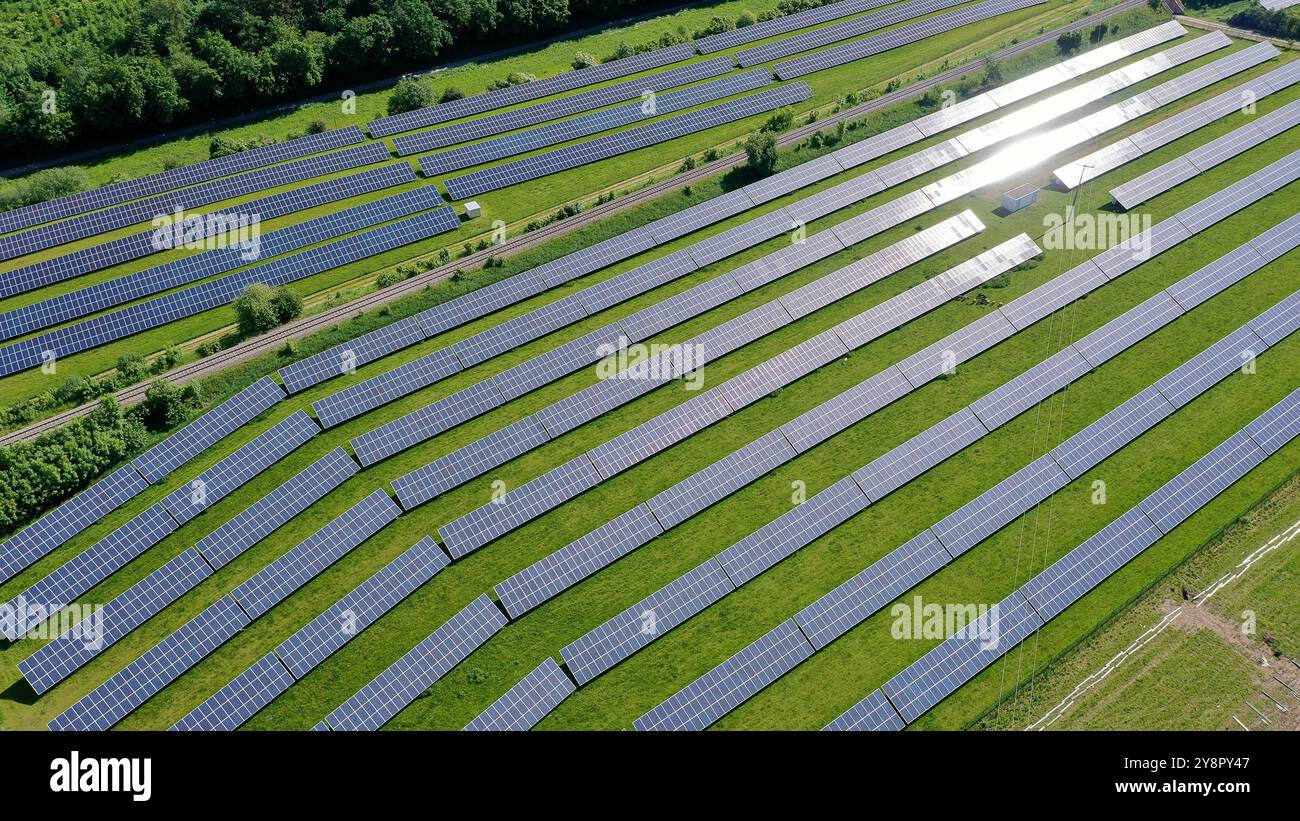 Questa splendida vista aerea cattura un vasto campo solare, che mostra una vasta gamma di pannelli solari che sfruttano l'energia del sole. La griglia ordinata si trova Foto Stock