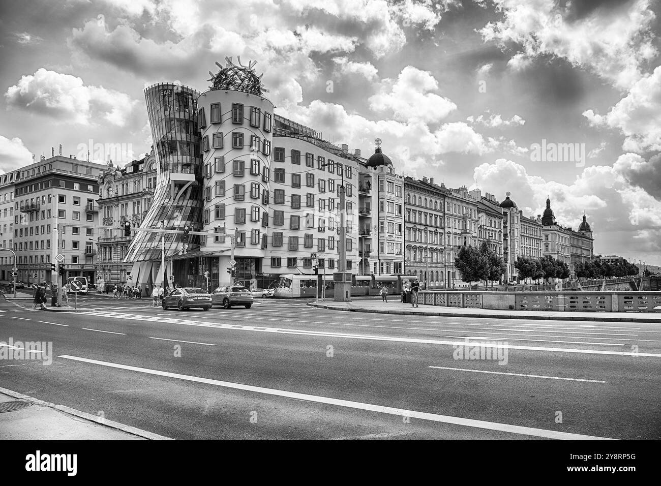 PRAGA - 12 MAGGIO 2024: Turisti e gente del posto stanno attraversando la strada vicino alla Dancing House, edificio iconico di Praga, Repubblica Ceca Foto Stock