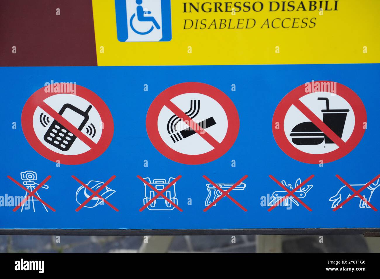 Un cartello ufficiale d'ingresso al Vaticano a Roma, in Italia, che mostra informazioni di accesso per disabili e icone di oggetti proibiti per i pellegrini in visita. Foto Stock
