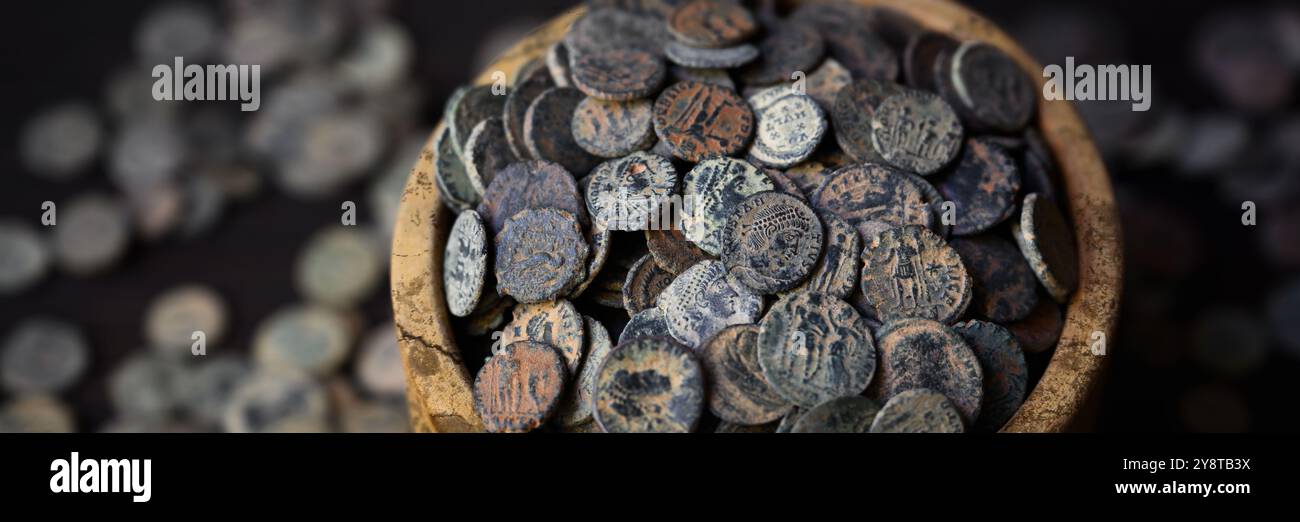 Antico tesoro di monete romane, striscione panoramico con un sacco di soldi antichi in vaso di legno, sfondo vintage. Concetto di Roma, antica, Impero, texture, civiliz Foto Stock