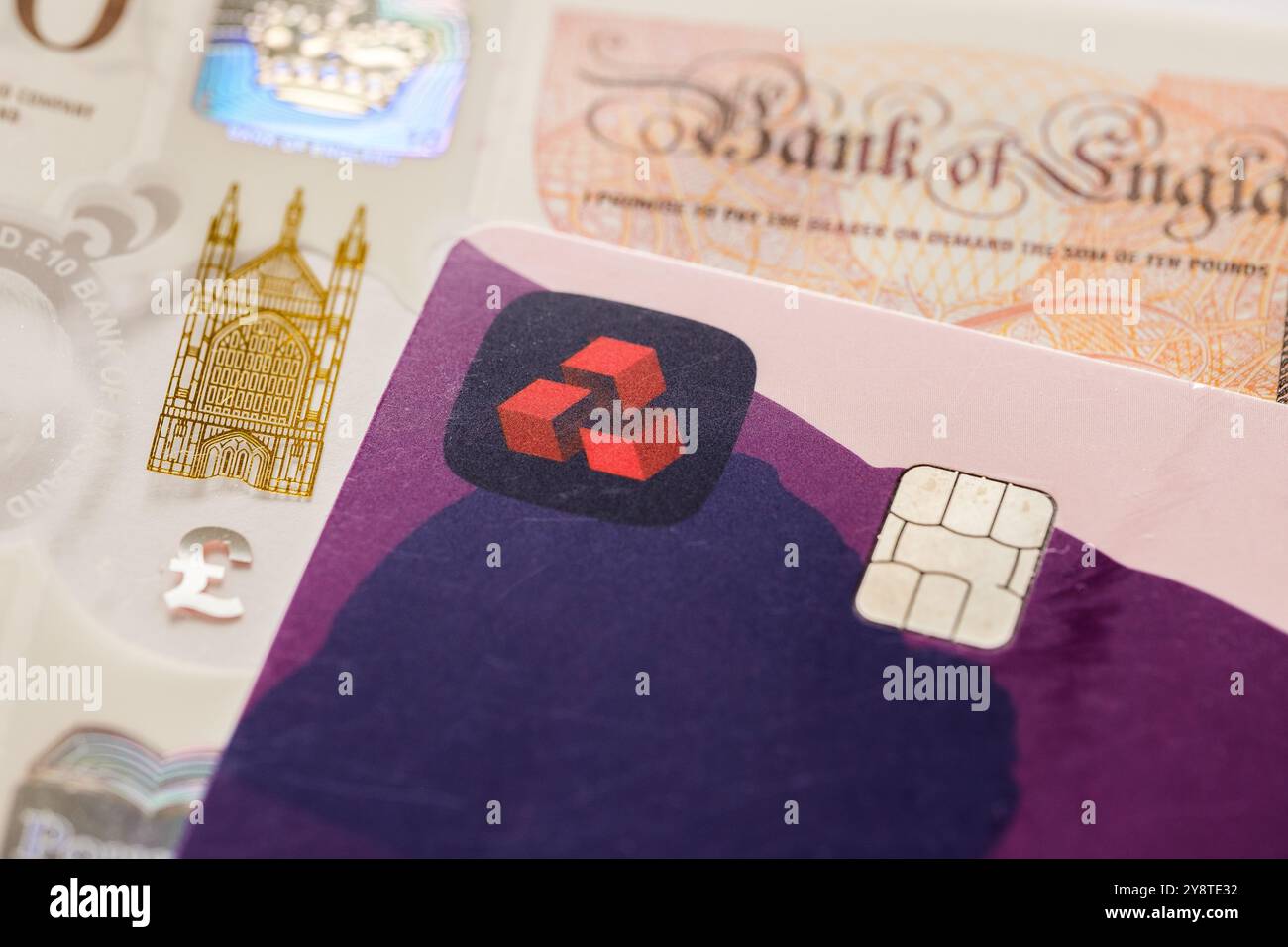 Primo piano con carta di debito NatWest e valuta britannica. La rappresentazione visiva del settore bancario tradizionale si è fusa con soluzioni di pagamento digitali e con il gestore finanziario Foto Stock