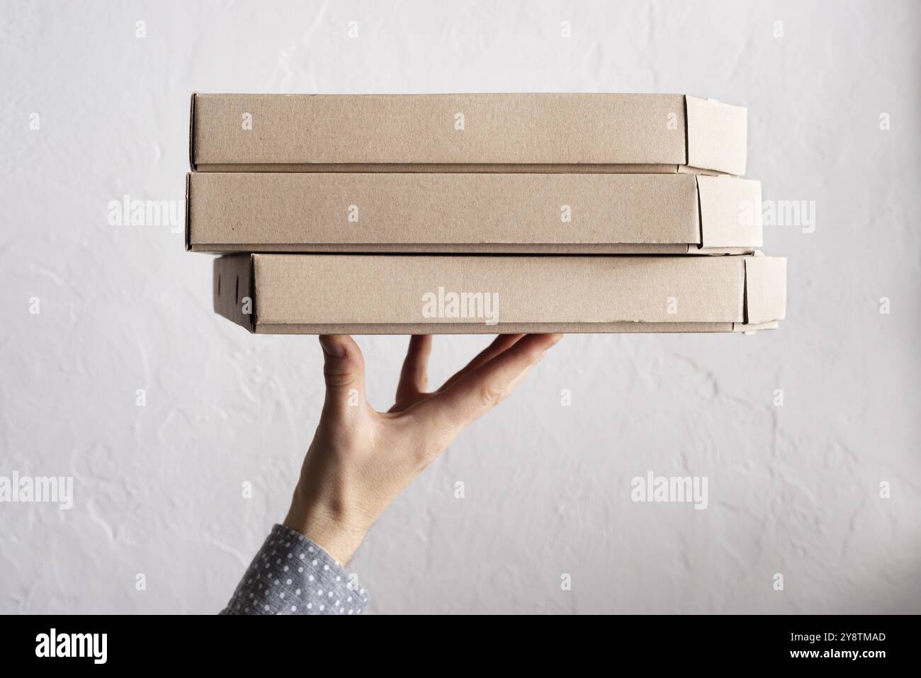 Le mani maschili caucasiche reggono la vista laterale di tre scatole per pizza con spazio per le copie Foto Stock