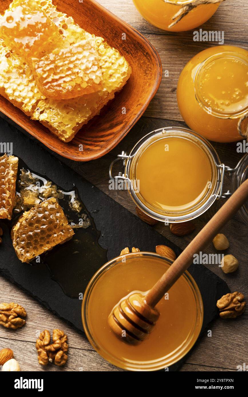 Nido d'ape su vassoio di ardesia con miele e noci sul tavolo da cucina Foto Stock
