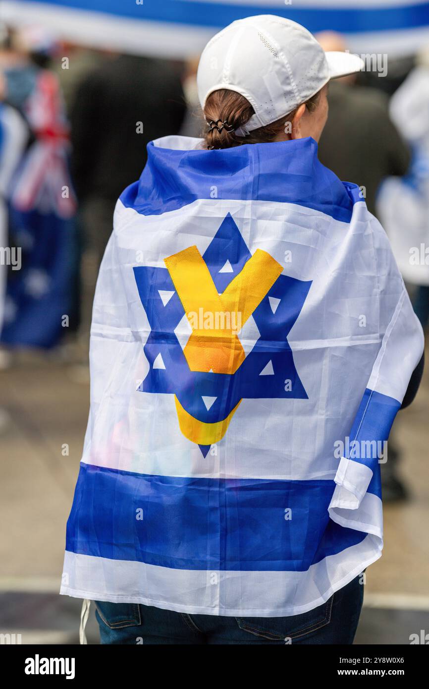 Melbourne, Australia. 6 ottobre 2024. Un manifestante è visto drappeggiato con una bandiera israeliana mentre i gruppi pro-Israele hanno segnato il primo anniversario degli attacchi del 7 ottobre. Un raduno pro-Israele si è tenuto a Melbourne, in coincidenza con il primo anniversario degli attacchi del 7 ottobre, mentre i manifestanti si sono riuniti per mostrare sostegno a Israele nel mezzo del conflitto in corso con Hamas. I partecipanti al rally hanno sventolato le bandiere israeliane e tenuto striscioni che sostenevano il diritto di Israelís di difendersi, chiedendo la pace e la fine del terrorismo. Credito: SOPA Images Limited/Alamy Live News Foto Stock