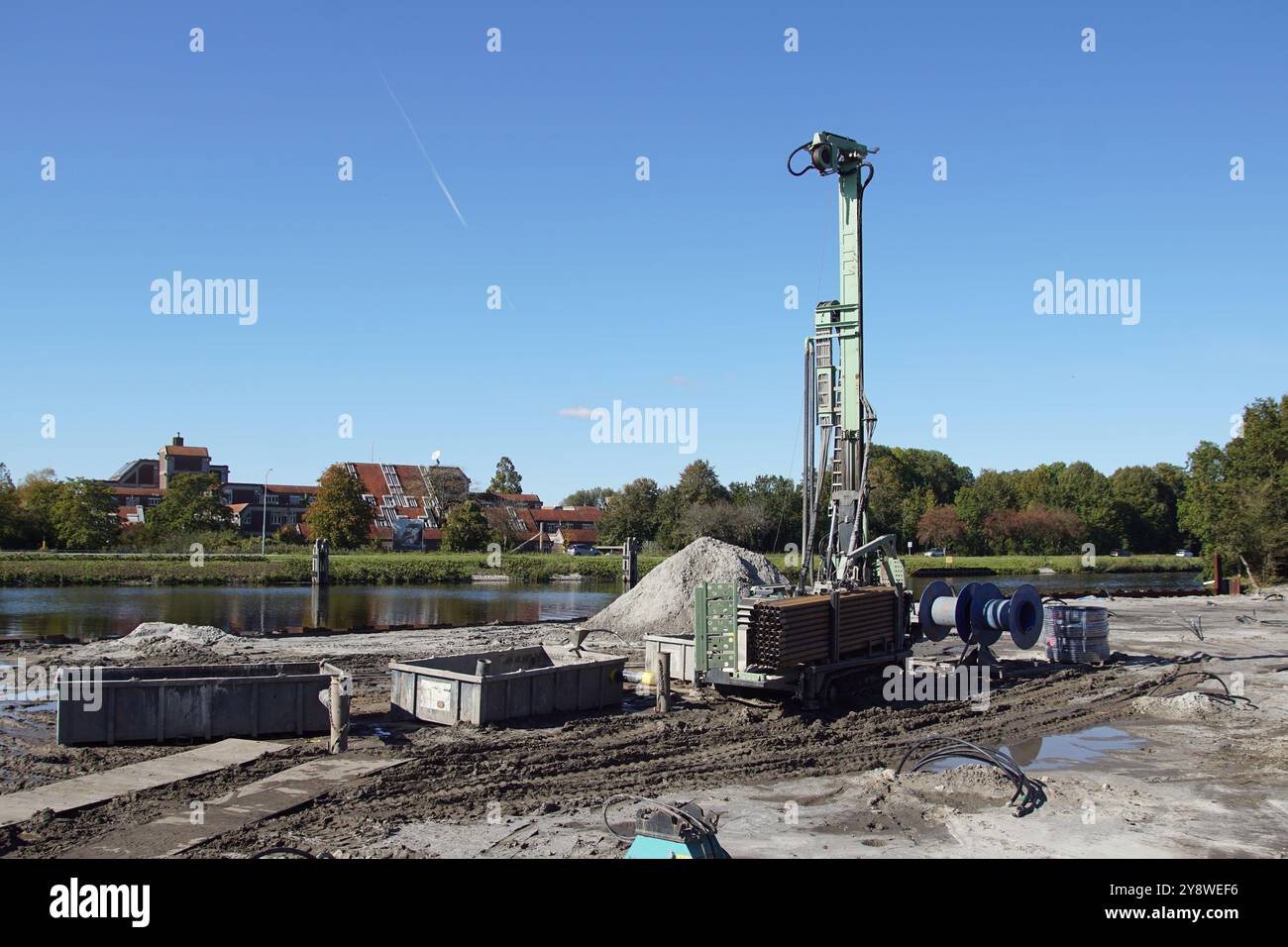 Perforatrice da terra per estrarre il calore geotermico dal suolo. Cantiere olandese vicino al canale (Noordhollandsch Kanaal) ad Alkmaar. Autunno, Foto Stock