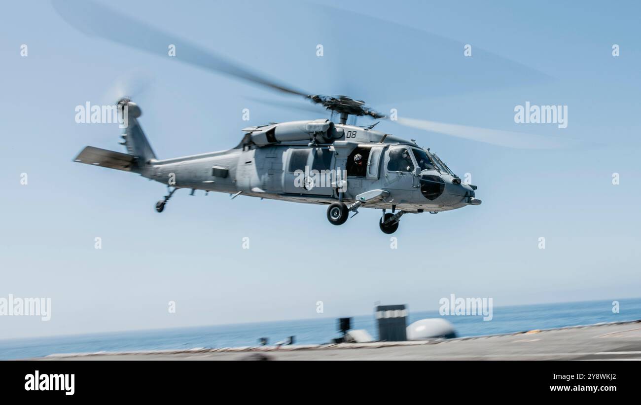 Un MH-60S Seahawk Helicopter, attaccato all'Helicopter Sea Combat Squadron (HSC) 3, decolla dalla cabina di pilotaggio della portaerei classe Nimitz USS Foto Stock