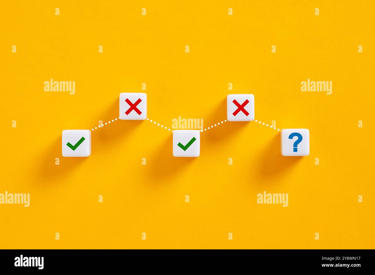 Punto interrogativo e segno di spunta e croce che formano un grafico su sfondo giallo, raffigurante il concetto di processo decisionale. Foto Stock