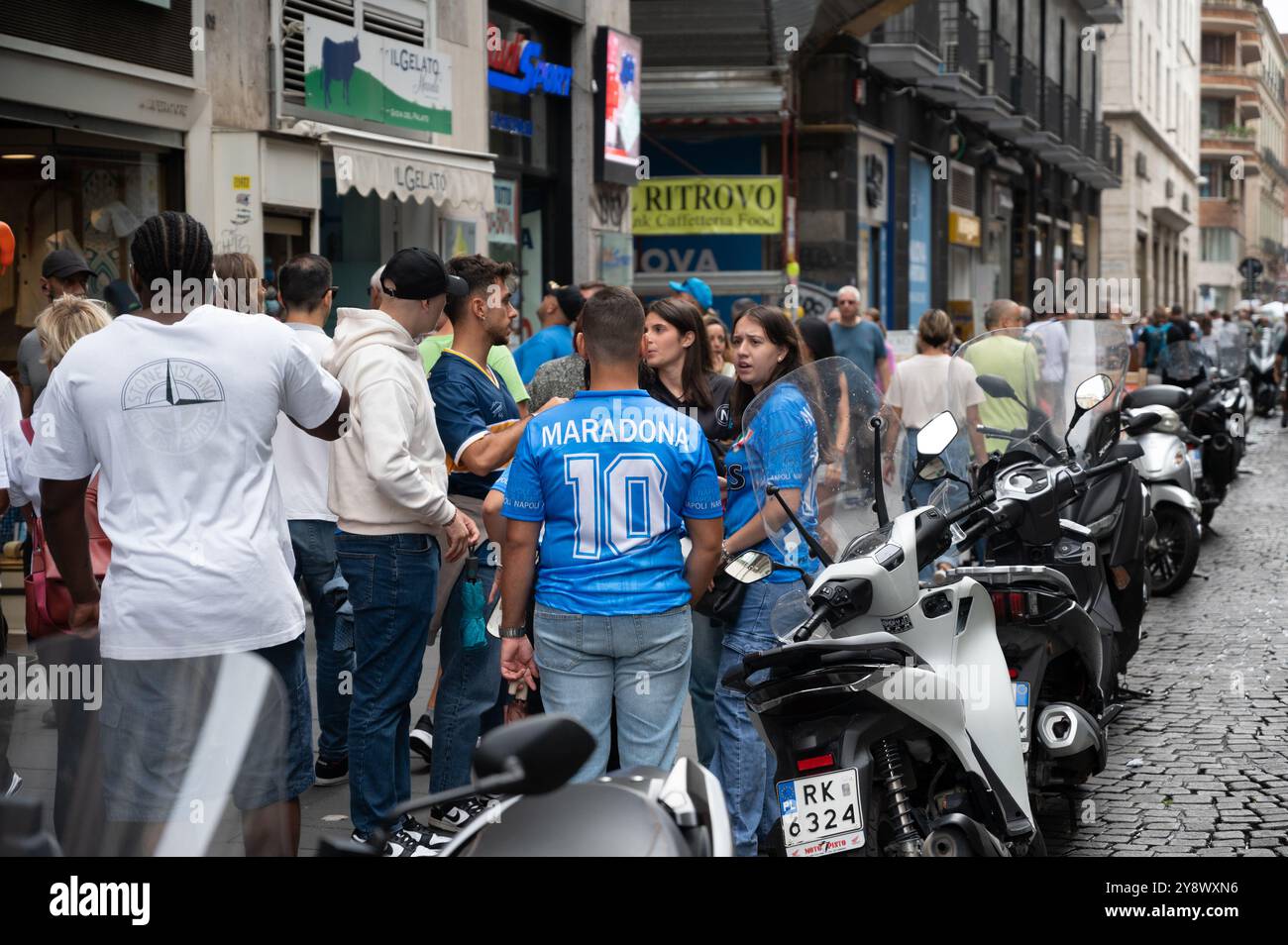 Adolescenti che indossano maglie da calcio Maradona in onore di Diego Maradona, che ha giocato per il Napoli e viene trattato con lo status di Dio in città Foto Stock