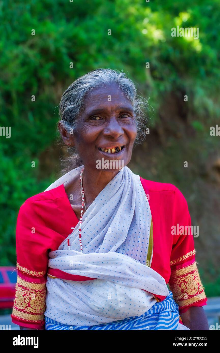 Felice sorridente signora dello Sri Lanka dai capelli voluminosi e con un brutto bisogno di un buon dentista, che implorerà a Rawana (aka Ruwana, Ravana) Ella Falls, Sri Lanka Foto Stock