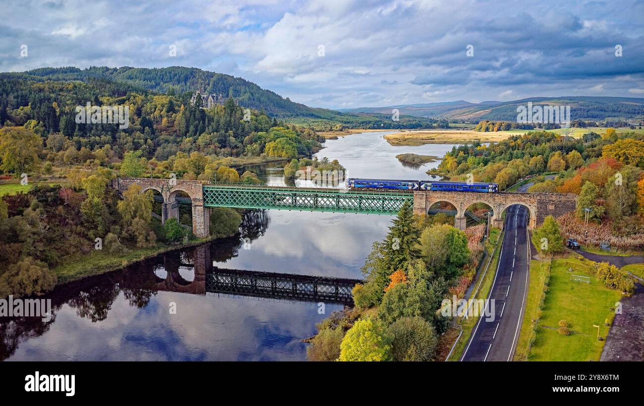Treno ScotRail sul viadotto della ferrovia Shin con Kyle of Sutherland e il castello di Carbisdale in autunno Foto Stock