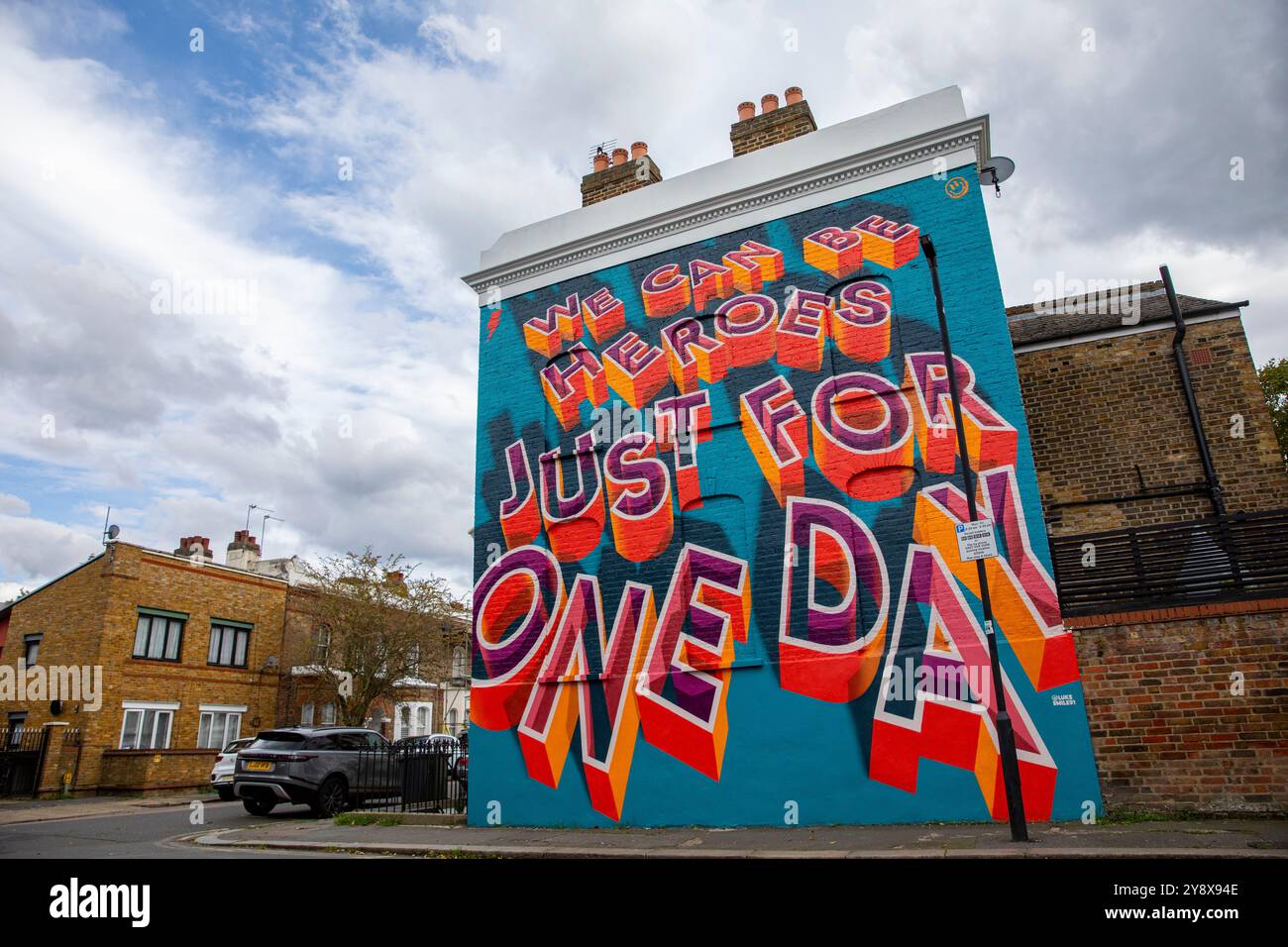 Una casa vittoriana a Brixton con le parole 'We CAN Be Heroes Just for One Day' in colorati graffiti di Street art - Londra il 29 settembre 2024. Foto Stock