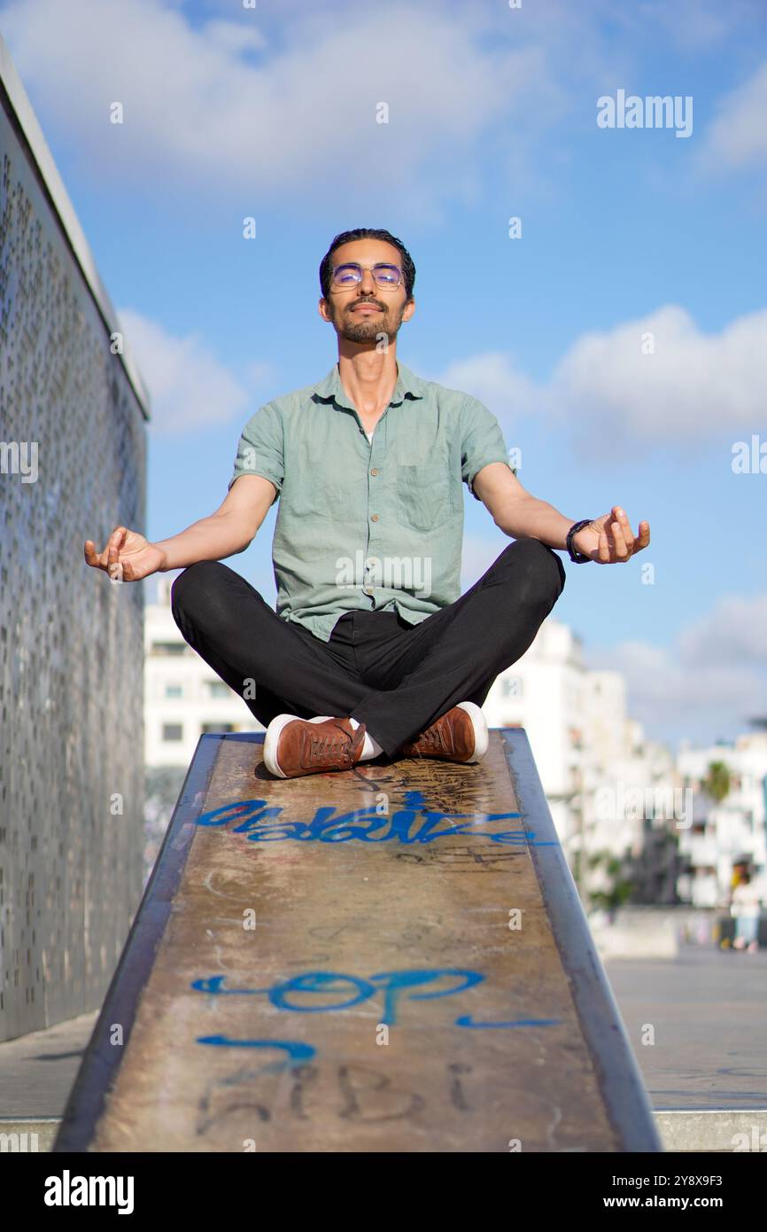 Uomo arabo zen pacticing yoga sullo skate Park nevada a Casablanca in Marocco Foto Stock