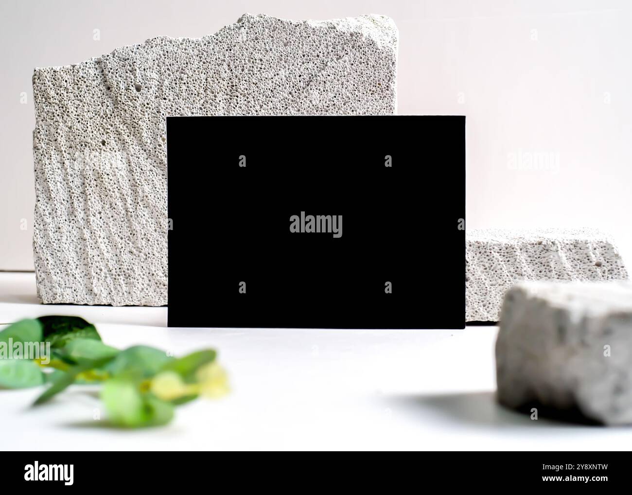 Un sofisticato mockup di carte nere elegantemente visualizzato su un pulito sfondo in pietra bianca. Questo design minimalista mette in risalto l'eleganza e le vers Foto Stock