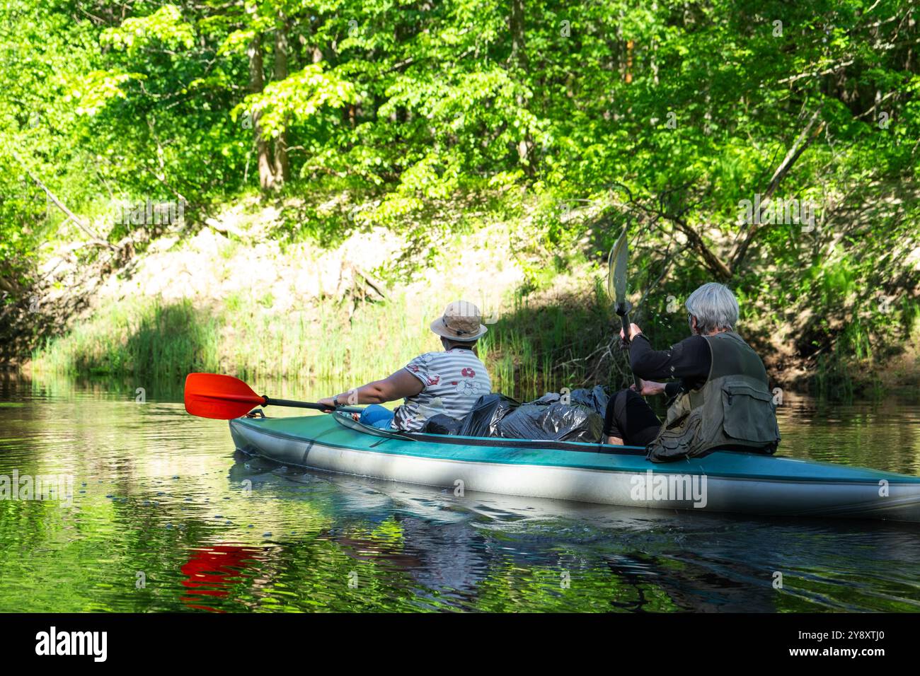Gita in kayak per famiglie per il signore e senora. Una coppia sposata anziana che canoa una barca sul fiume, un'escursione in acqua, un'avventura estiva. Sport legati all'età, Foto Stock