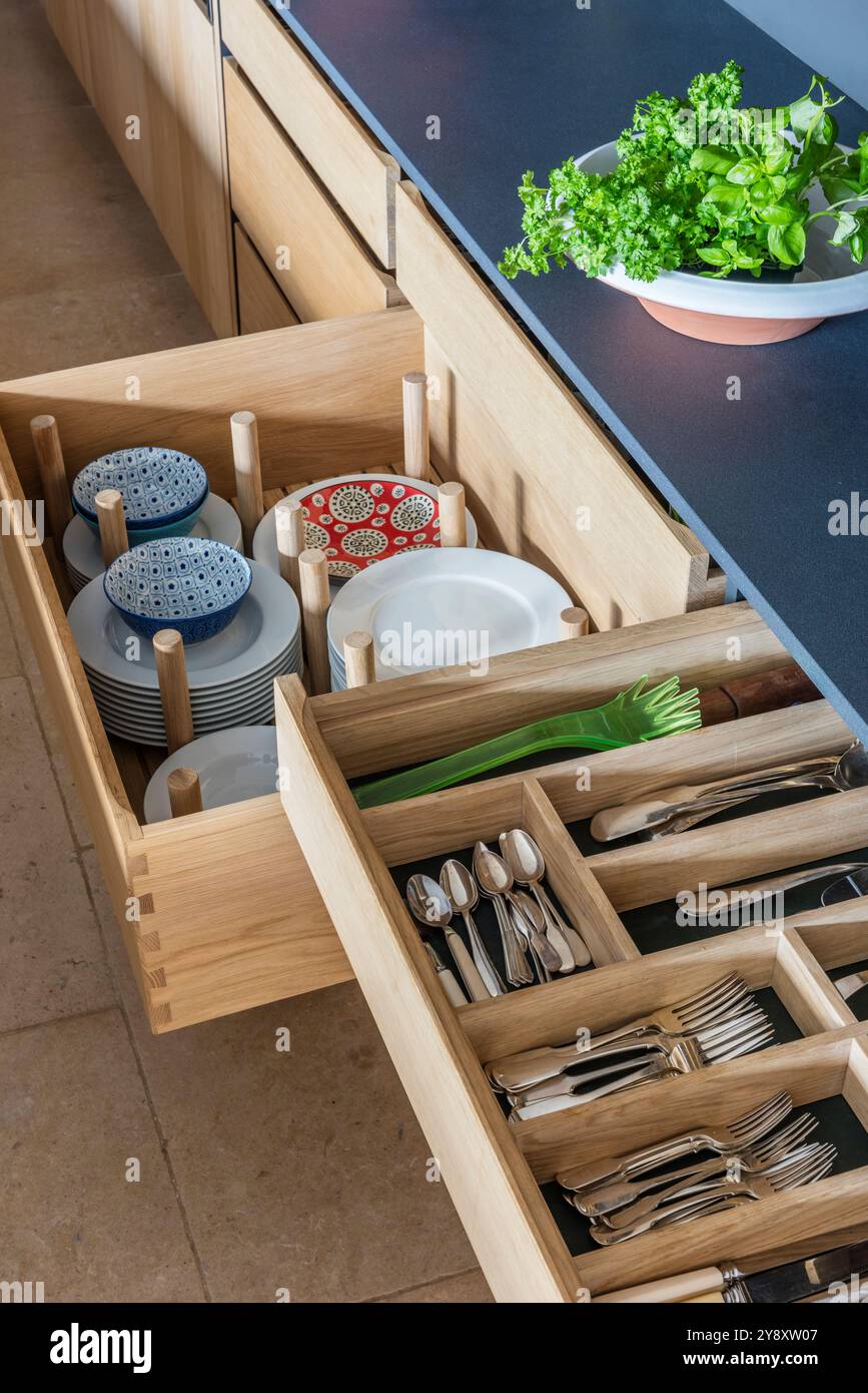 Deposito di piatti, ciotole e posate in una cucina di design, Gloucestershire, Inghilterra, Regno Unito Foto Stock