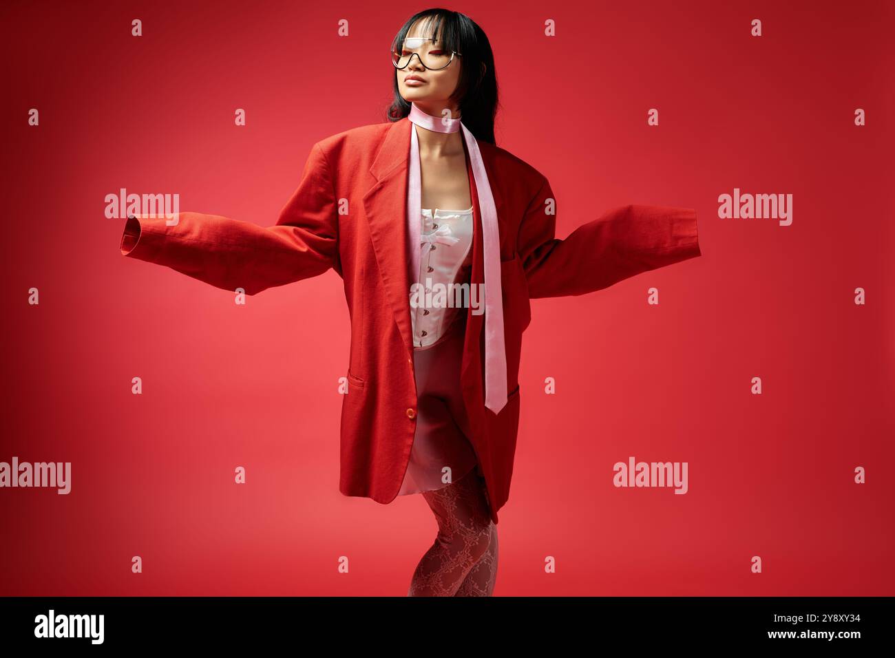 La donna sicura di sé mette in mostra il suo stile unico, unendo l'eleganza giocosa a scelte di moda audaci. Foto Stock