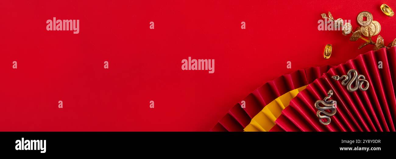 Capodanno cinese asia sfondo rosso dorato. Nuovo biglietto d'auguri per l'anno zodiaco Snake 2025. Sfondo piatto rosso con ventole natalizie, buste dei desideri, n. di serie Foto Stock