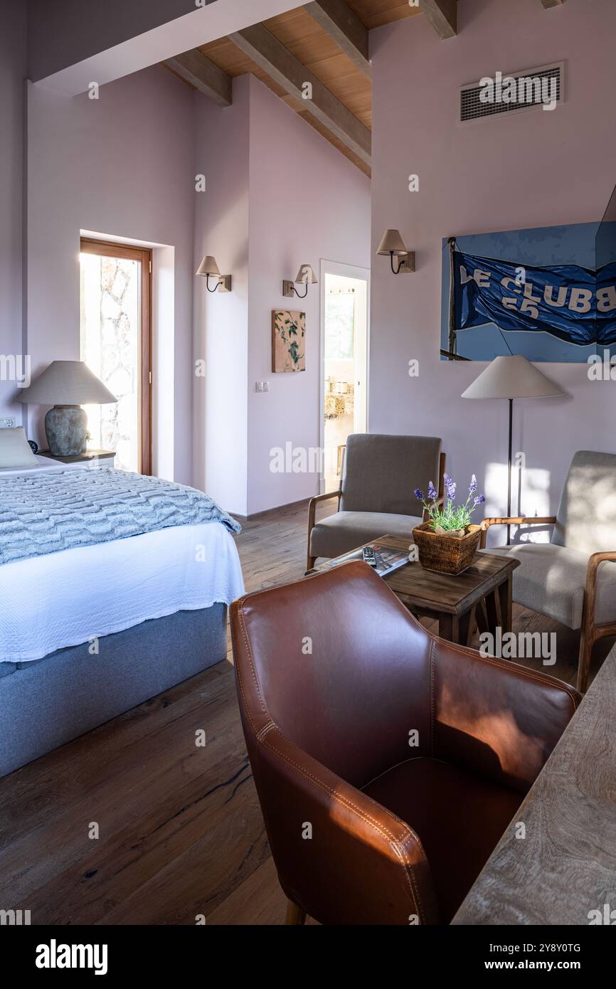 Poltrona in pelle marrone con opere d'arte "le club 55" nella camera da letto della villa spagnola di Maiorca. Foto Stock
