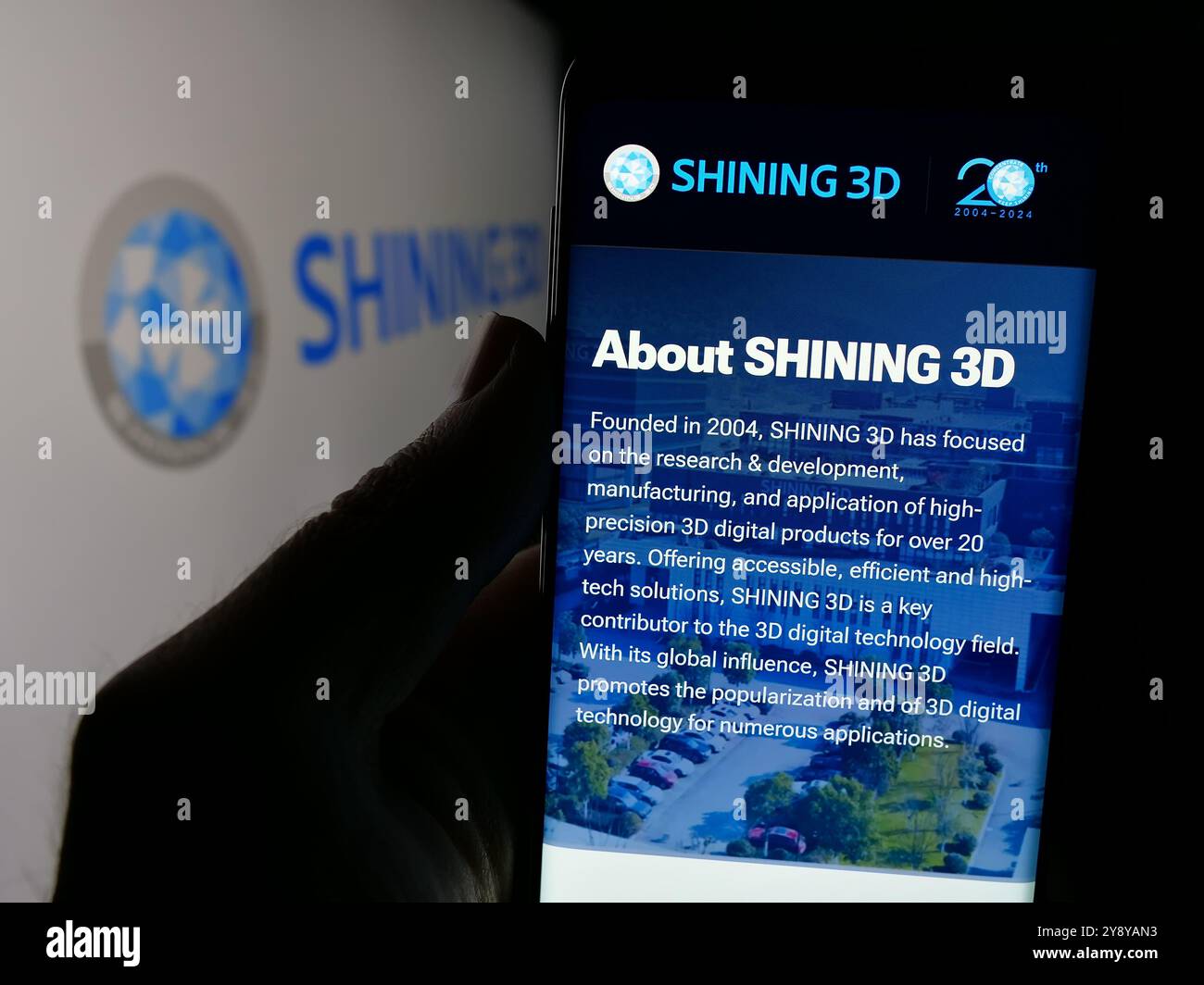 Persona che detiene un cellulare con pagina web della società cinese Hangzhou Shining 3D Co. Ltd. Sullo schermo con logo. Messa a fuoco al centro del display del telefono. Foto Stock
