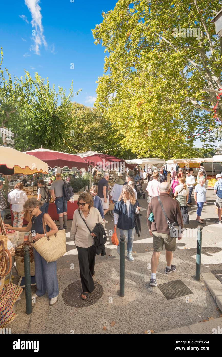 Persone che camminano attraverso un mercato all'aperto in strada a Lourmarin, Provenza, Francia Foto Stock