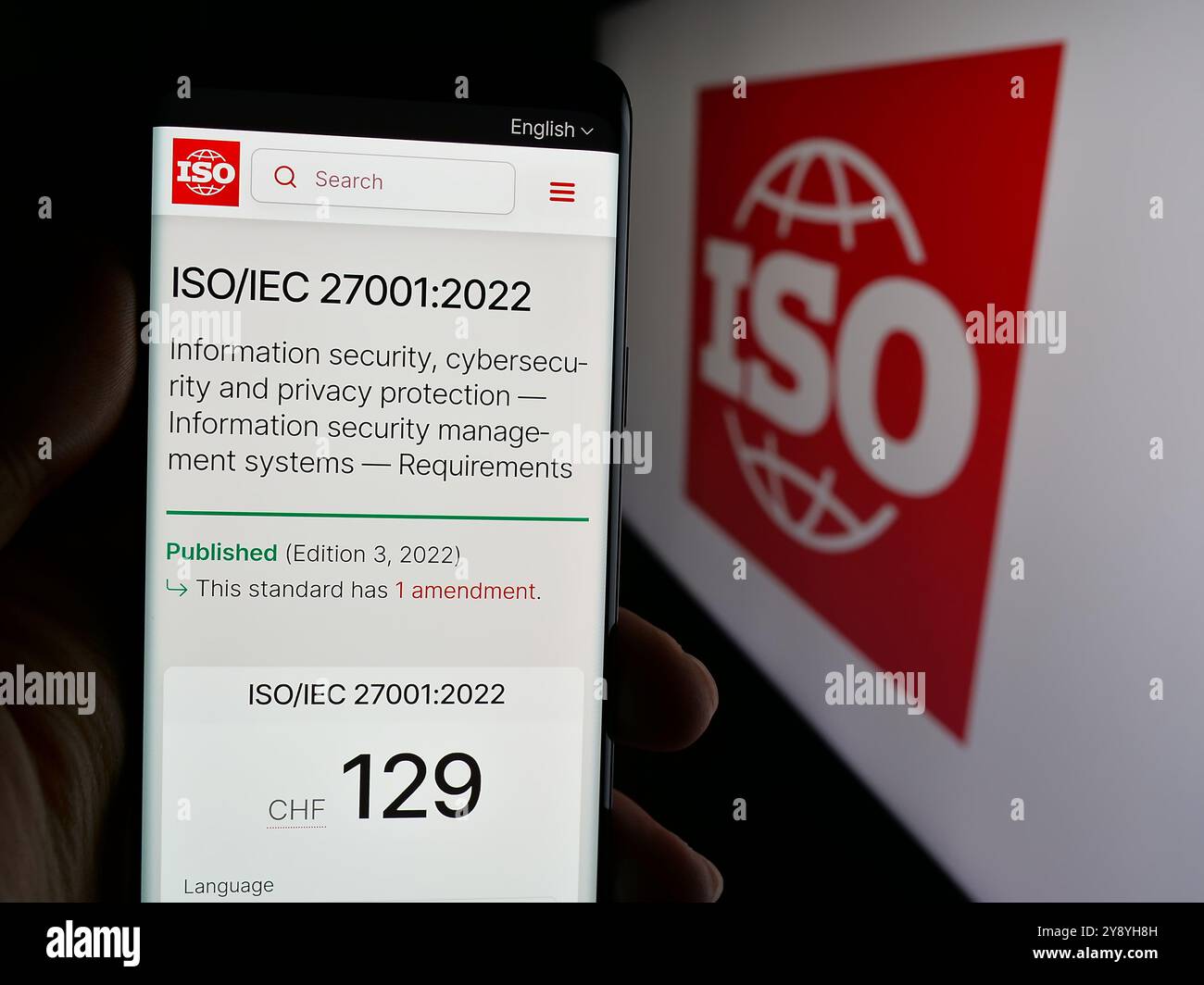 Persona che tiene il telefono con il sito Web dell'Organizzazione internazionale per la standardizzazione (ISO) sullo schermo con il logo. Messa a fuoco al centro del display del telefono. Foto Stock