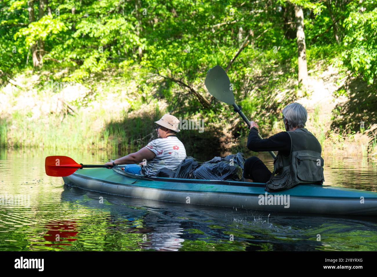 Gita in kayak per famiglie per il signore e senora. Una coppia sposata anziana che canoa una barca sul fiume, un'escursione in acqua, un'avventura estiva. Sport legati all'età, Foto Stock