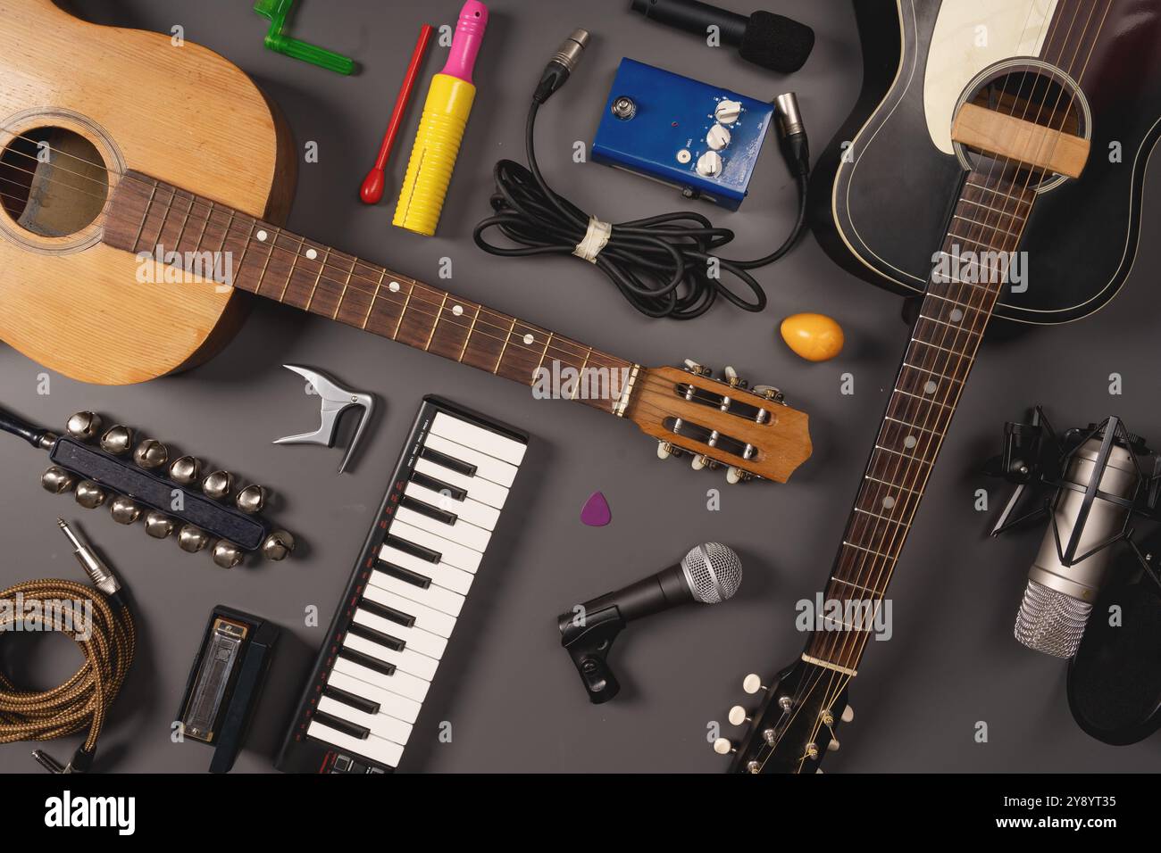 Vista dall'alto di vari strumenti musicali e attrezzature, tra cui chitarre acustiche ed elettriche, tastiera, microfoni, cavi e accessori. MU Foto Stock