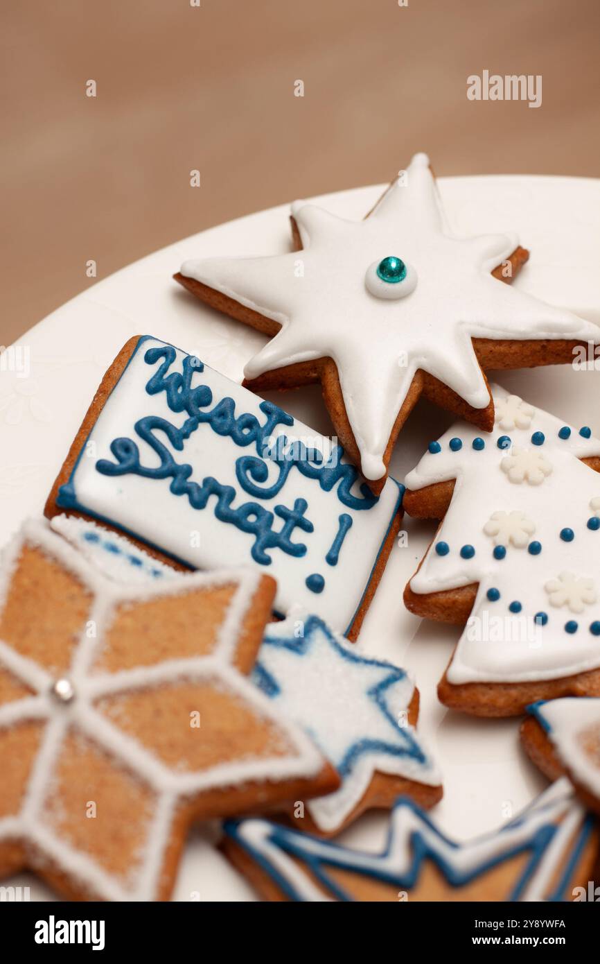 Biscotti di pan di zenzero di Natale polacco decorati con glassa reale con scritta "Wesołych Świąt" - auguri di "buon Natale" in polacco Foto Stock
