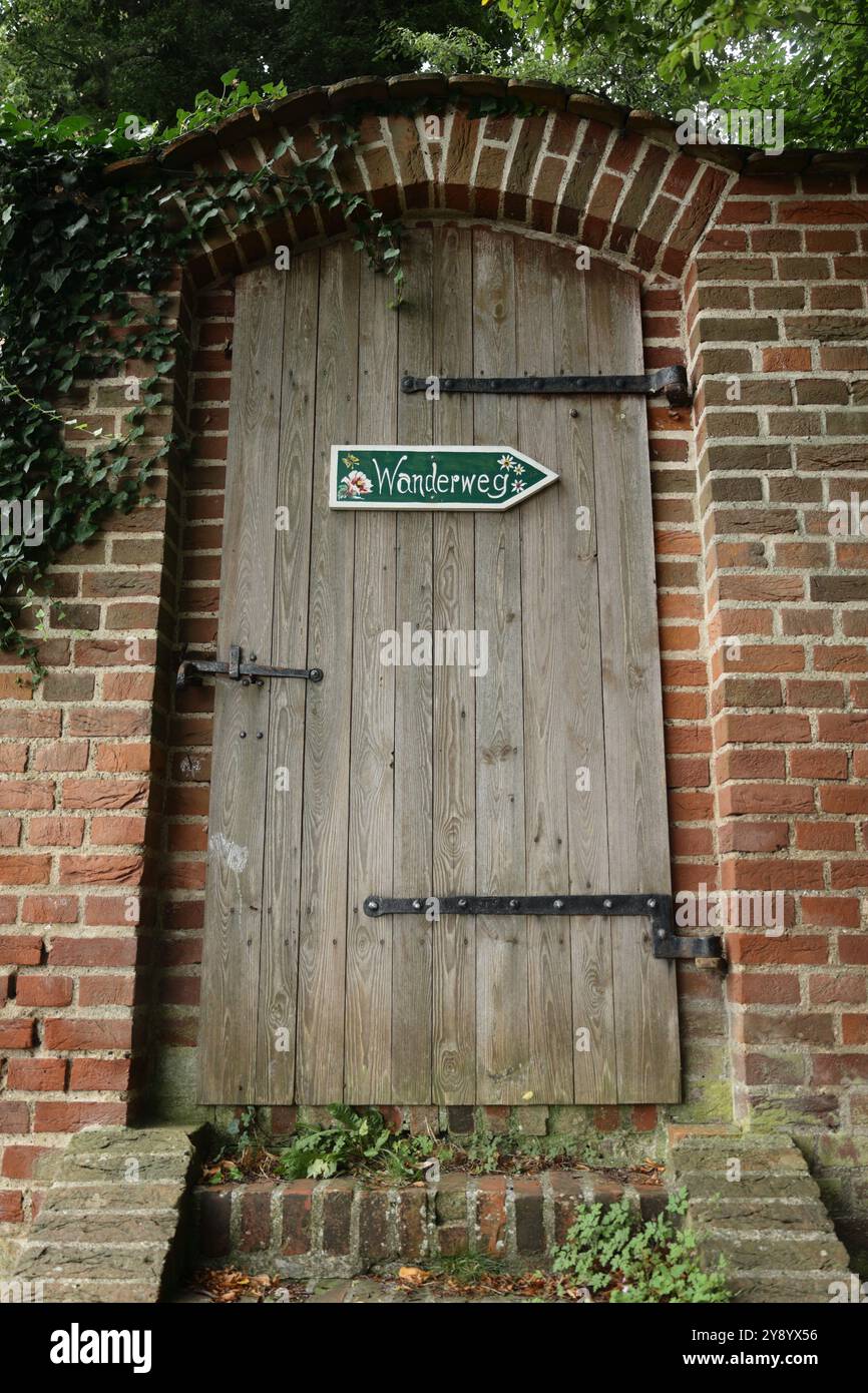 Porta di legno con un cartello che indica un sentiero escursionistico Foto Stock