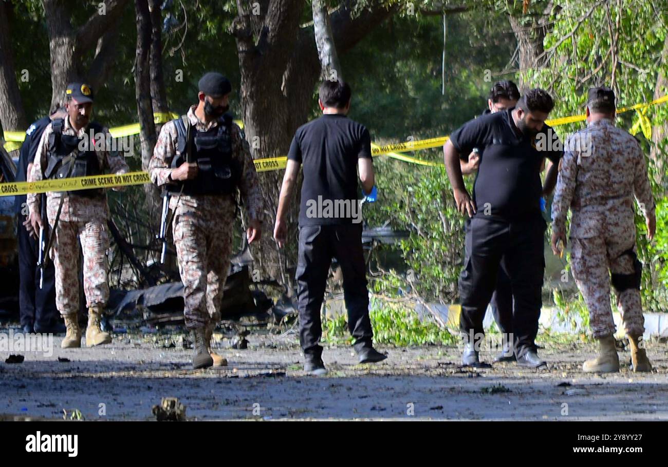 Vista del sito mentre i funzionari della sicurezza sono cordone fuori dal sito per le operazioni di ispezione e indagine dopo un'enorme esplosione nei pressi dell'aeroporto internazionale Jinnah di Karachi lunedì 7 ottobre 2024. Almeno tre cittadini stranieri sono morti, mentre altri 17 hanno subito lesioni in un'enorme esplosione vicino all'aeroporto internazionale di Jinnah. Il rumore dell'esplosione è stato sentito in diverse aree della città, tra cui Karimabad, Defence e Jamshed Road, enormi e spesse nuvole di fumo e un incendio ardente dal sito. Foto Stock