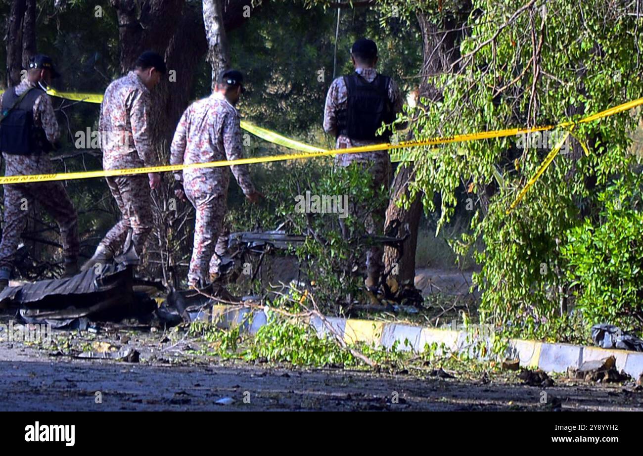 Vista del sito mentre i funzionari della sicurezza sono cordone fuori dal sito per le operazioni di ispezione e indagine dopo un'enorme esplosione nei pressi dell'aeroporto internazionale Jinnah di Karachi lunedì 7 ottobre 2024. Almeno tre cittadini stranieri sono morti, mentre altri 17 hanno subito lesioni in un'enorme esplosione vicino all'aeroporto internazionale di Jinnah. Il rumore dell'esplosione è stato sentito in diverse aree della città, tra cui Karimabad, Defence e Jamshed Road, enormi e spesse nuvole di fumo e un incendio ardente dal sito. Foto Stock