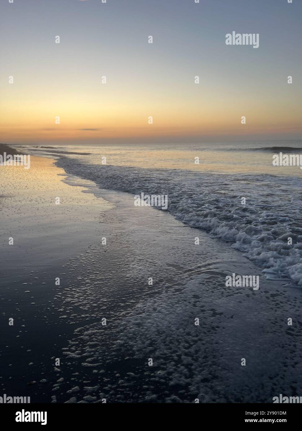 Tramonto arcobaleno sulle tranquille onde dell'oceano con sabbia sulla spiaggia - Immagine stock catturata con smartphone