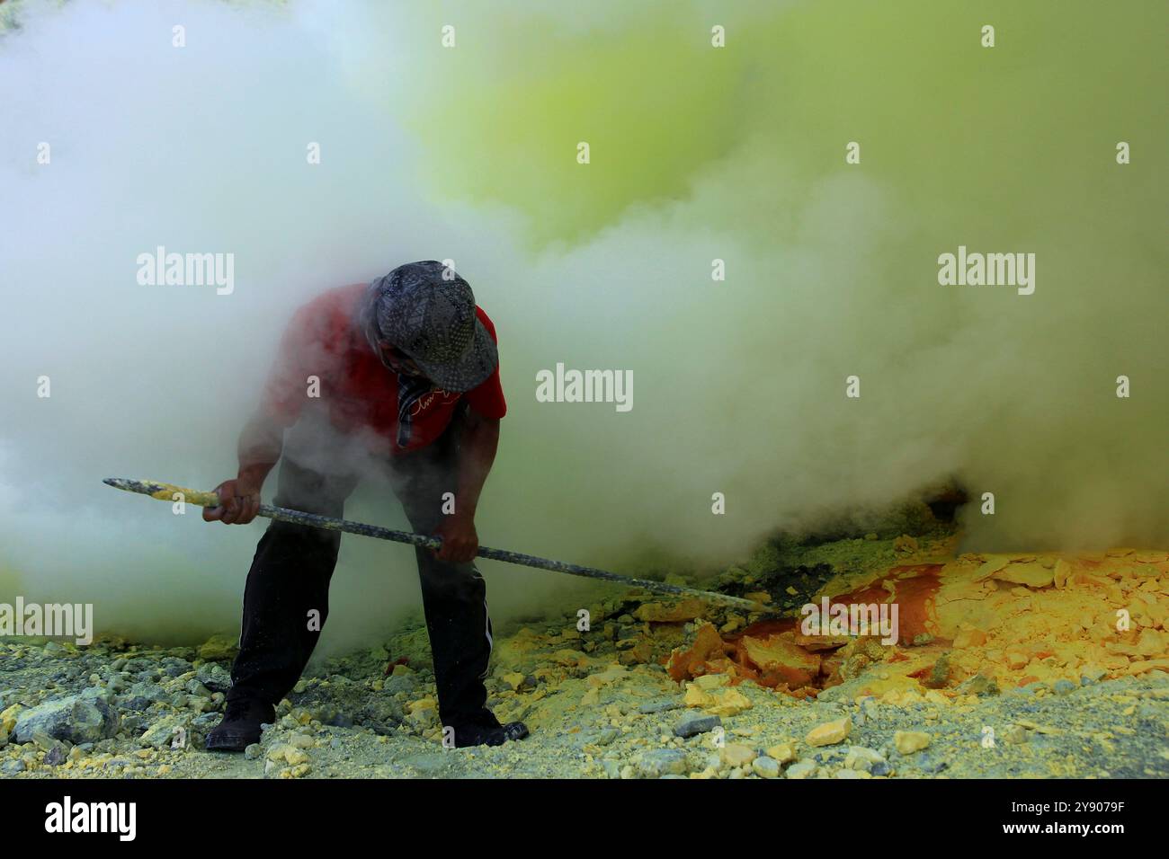 Minatori di zolfo nel cratere di Ijen. Lo stato di salute dei minatori è molto rischioso perché non è dotato di adeguate attrezzature di sicurezza standard. Foto Stock