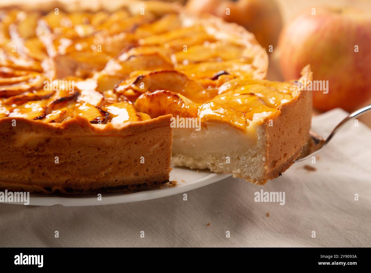 Fetta di tradizionale torta di mele fatta in casa con ripieno di panna e copertura di marmellata, un classico dessert o spuntino autunnale o invernale Foto Stock
