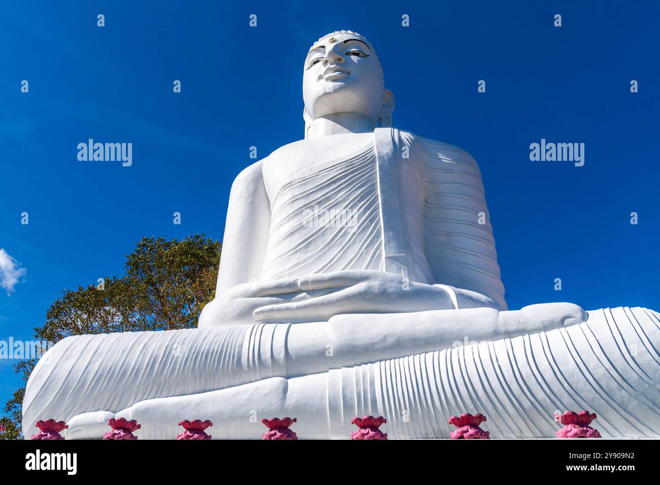 Sri Lanka, Asia - 21 dicembre 2023: La statua del Buddha di Bahiravokanda Vihara si erge in bianco brillante contro un cielo azzurro nello Sri Lanka. Simboleggia la pace e l'illuminazione ed è un simbolo del potere spirituale *** Die Bahiravokanda Vihara Buddha Statue erhebt sich in strahlendem Weiß vor einem klaren, blauen Himmel in Sri Lanka. SIE symbolisiert Frieden und Erleuchtung und ist ein Wahrzeichen spiritueller Kraft Foto Stock