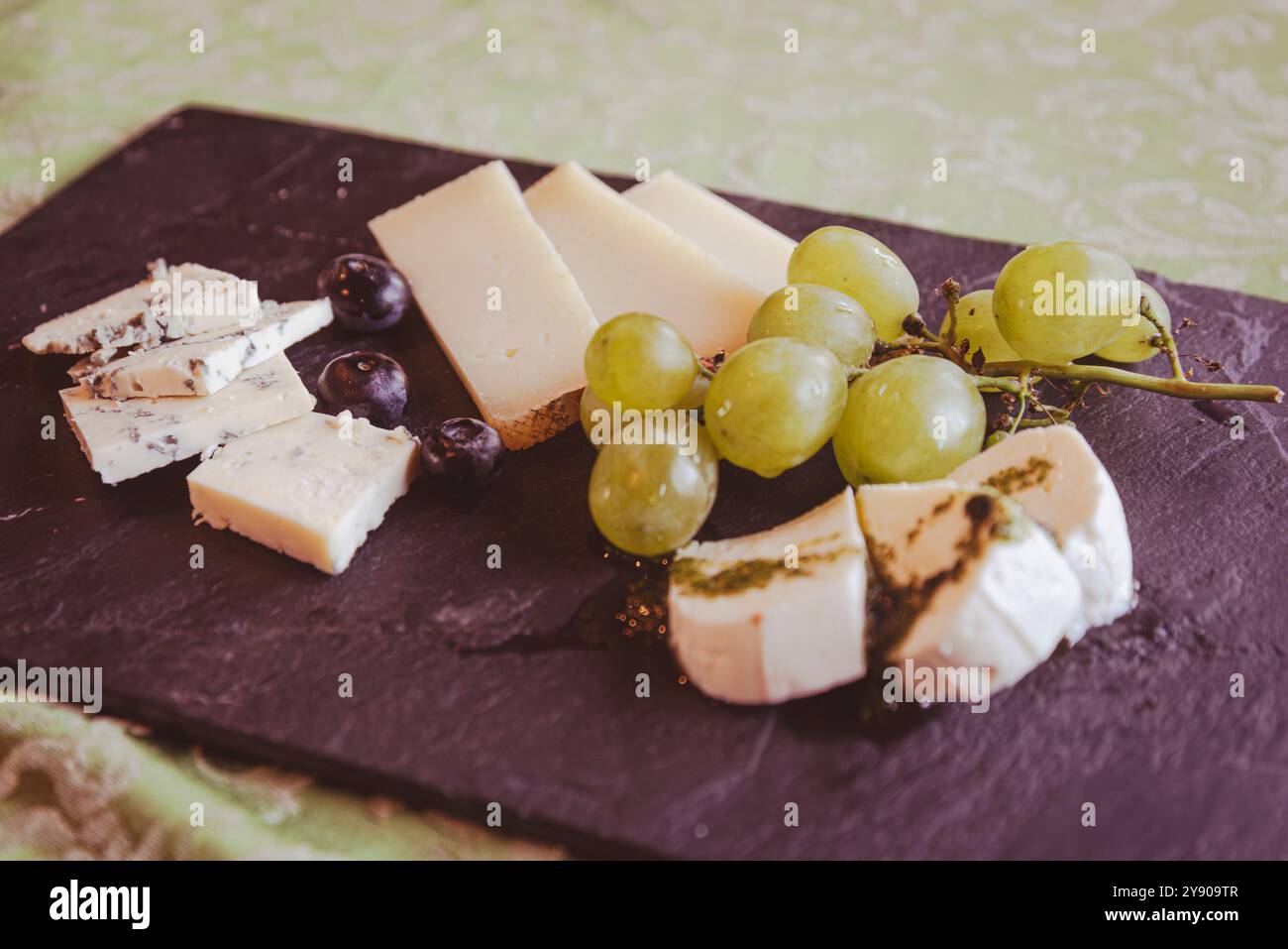 Un tavolo di fette di formaggio è la conclusione perfetta di un pasto tipico, di un delizioso aperitivo o di uno spuntino molto ricco. Foto Stock