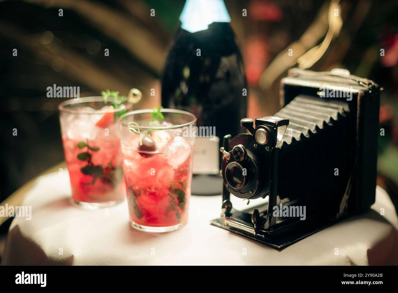 Tavolo curios con cocktail e macchina fotografica vintage. Foto Stock