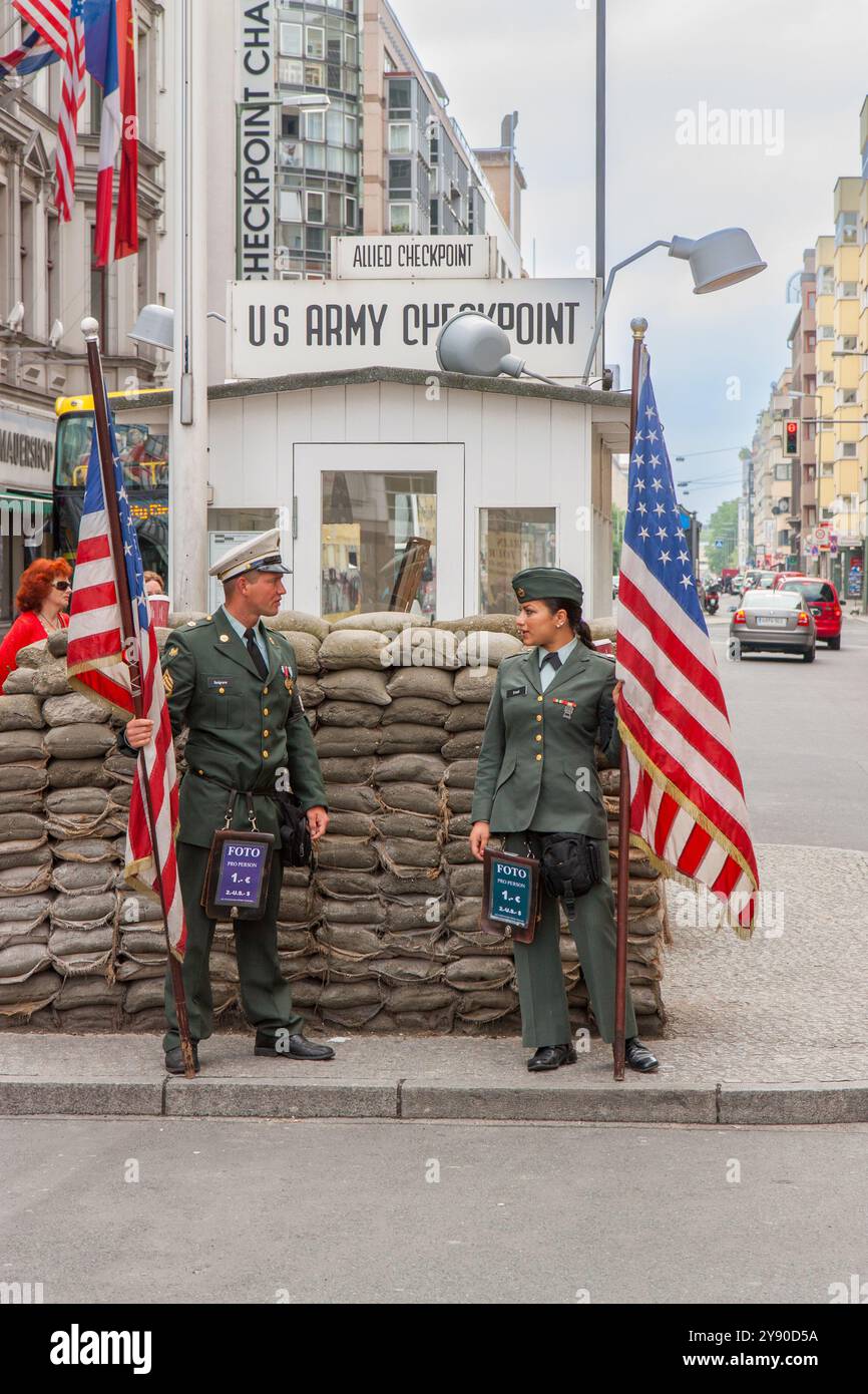 Berlino, Germania 30 maggio 2009. Checkpoint Charlie Berlin. Due soldati americani, uomo e donna, con una bandiera americana in mano. Foto Stock
