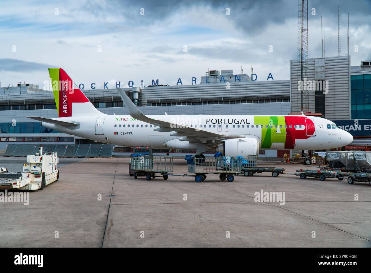 TOCCARE Transportes Aéreos Portugueses Airbus A320 all'aeroporto Arlanda di Stoccolma all'uscita, Terminal 5 dell'aeroporto sullo sfondo. Foto Stock