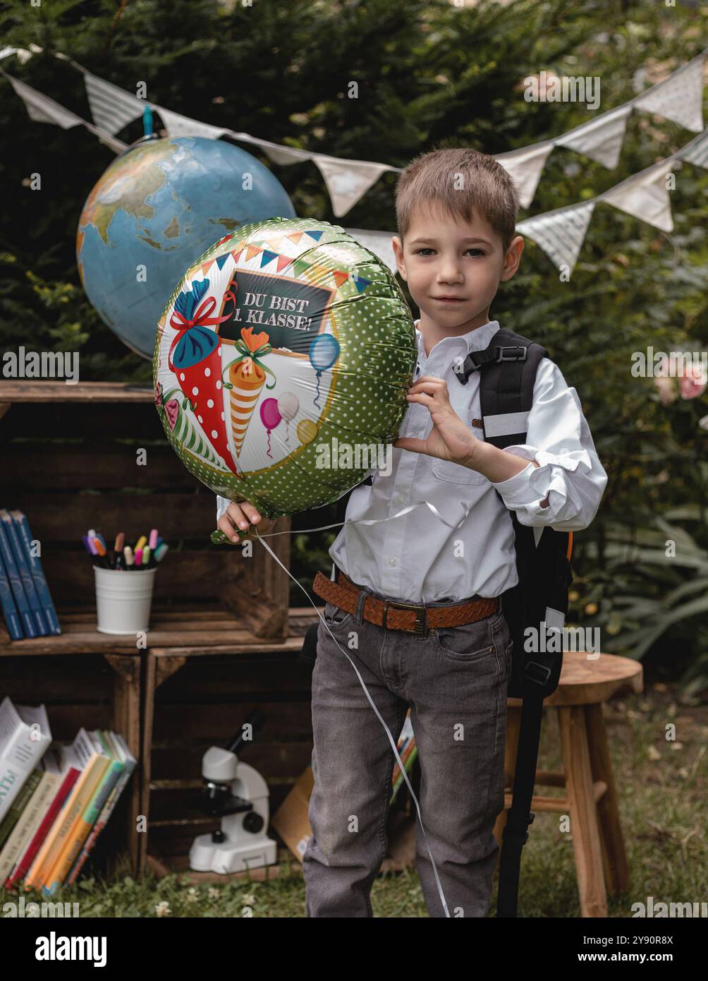 Una prima elementare. Il ragazzo va a scuola. Uno scolaro tiene un pallone tra le mani. Foto di alta qualità Foto Stock