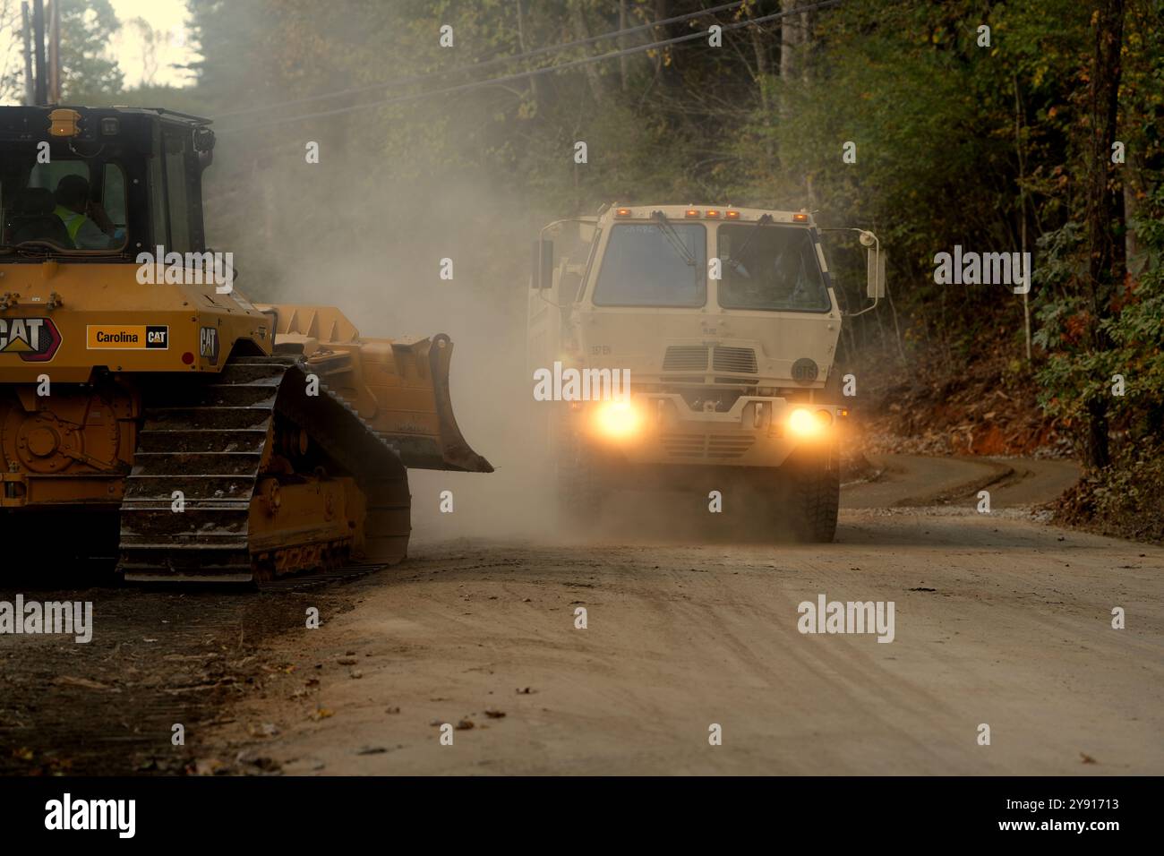 Un 357th Engineer Company FMTV 10-Ton Dump Truck sgancia grandi massi da un piede all'altro all'alluce meridionale nella contea di Yancey come parte degli sforzi di stabilizzazione per rinforzare le aree colpite dalle recenti frane durante le operazioni di recupero in corso a Burnsville, North Carolina (contea di Yancey). Foto Stock