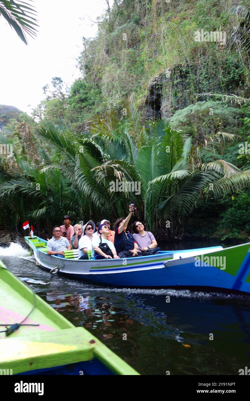 Turisti che scattano selfie in barca da Rammang Rammang, Leang Leang Valley, vicino a Makassar, Sulawesi, Indonesia. No MR Foto Stock