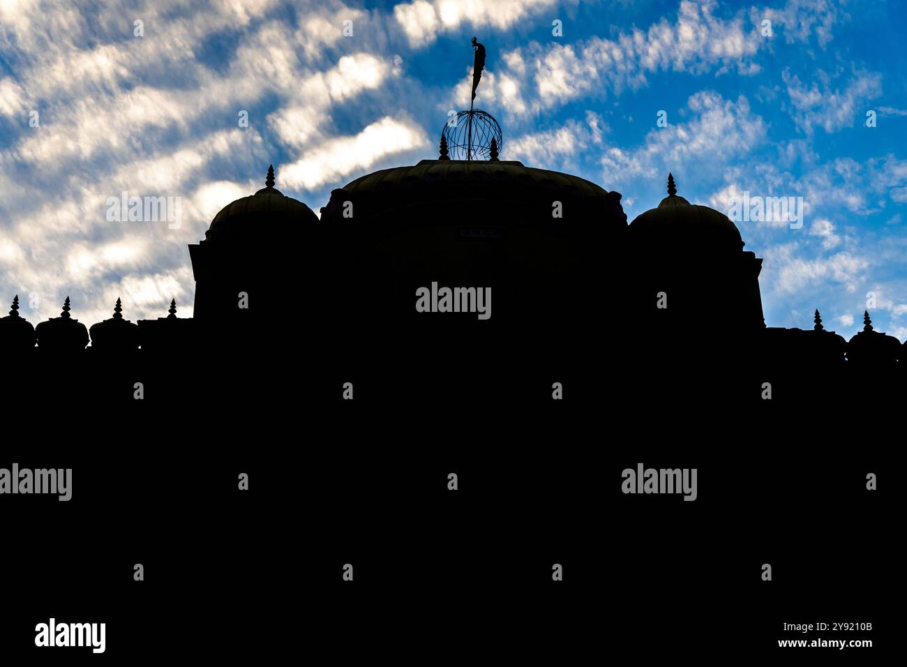 Retroilluminato del Sacro tempio indù con la sua architettura vibrante e il cielo spettacolare di sera Foto Stock