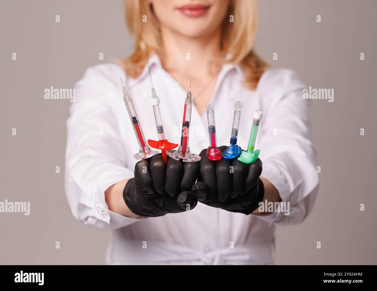 donna cosmetologa tiene siringhe cosmetologia primo piano, cura professionale della pelle per la sua salute, gioventù e bellezza, cosmetologia moderna e medicina estetica Foto Stock