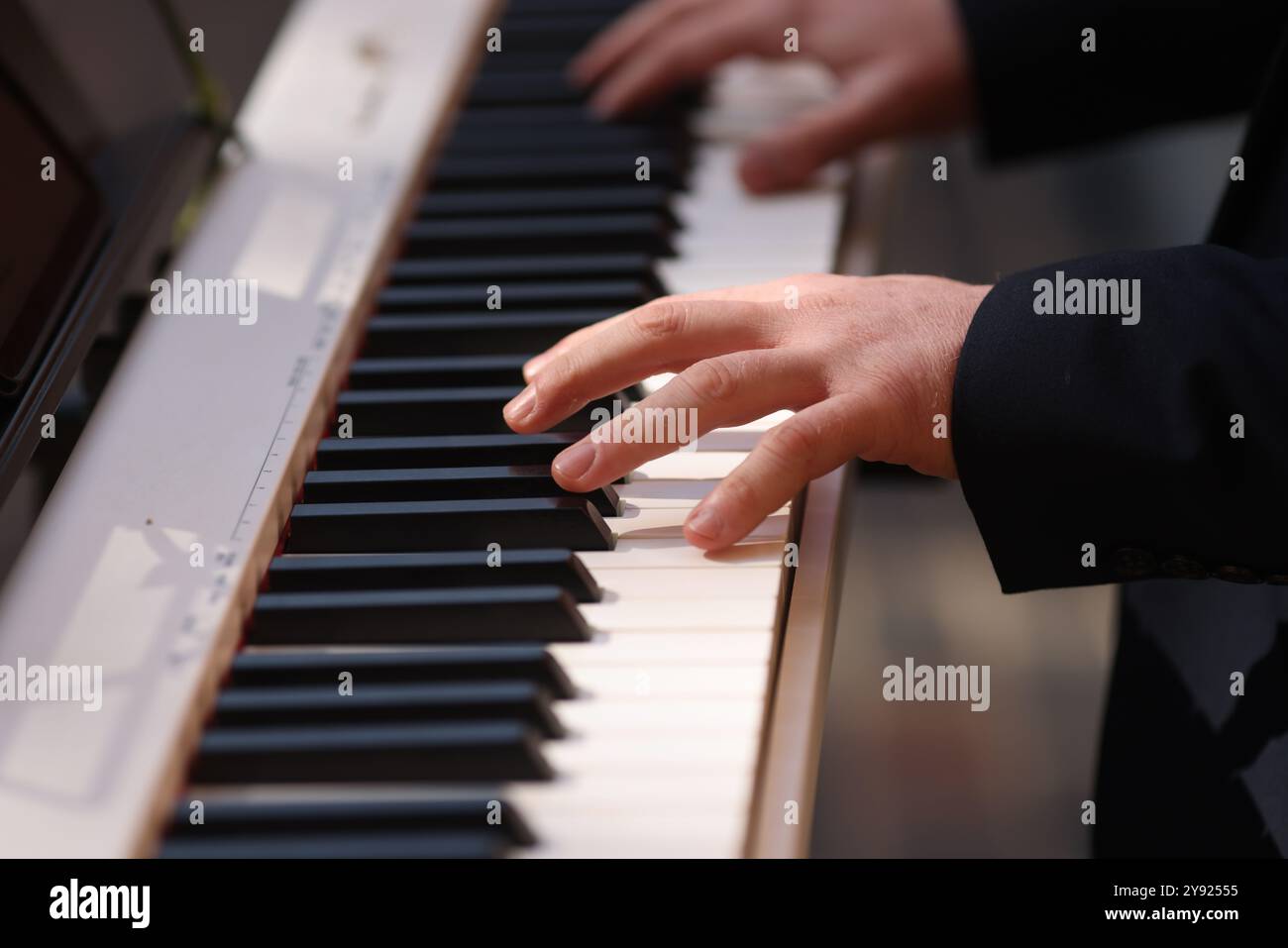 Dettagli con le mani di un uomo che suona un pianoforte elettrico. Foto Stock