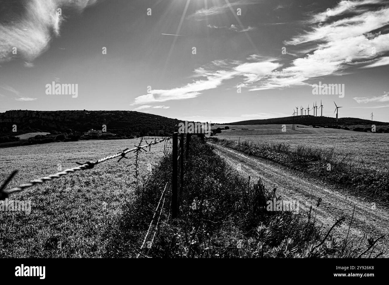 Filo spinato lungo un percorso chiuso ad anello con turbina eolica riassumere le difficoltà ecologico che sperimentiamo Foto Stock